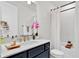 Stylish bathroom with dark blue vanity, quartz countertop, and shower with glass door at 3026 Prospect Trl, St Cloud, FL 34771