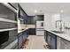 Modern kitchen featuring stainless steel appliances, blue cabinets, and a herringbone backsplash at 3026 Prospect Trl, St Cloud, FL 34771