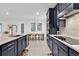 Spacious kitchen featuring navy cabinets, stainless steel appliances, and modern tile backsplash at 3026 Prospect Trl, St Cloud, FL 34771