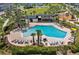 Aerial view of a community pool with lounge chairs, tables, and palm trees at 3026 Prospect Trl, St Cloud, FL 34771
