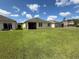 A spacious backyard featuring lush grass, the home's screened in porch, and neighboring homes at 306 Briar Patch Loop, Davenport, FL 33896