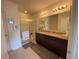 Bathroom featuring dual sinks, granite countertop, large mirrors, and a glass-enclosed shower at 306 Briar Patch Loop, Davenport, FL 33896