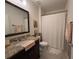 Bathroom featuring granite countertop, large mirror, toilet and shower with curtain at 306 Briar Patch Loop, Davenport, FL 33896