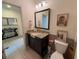 Bathroom featuring granite countertop, large mirror, and a toilet at 306 Briar Patch Loop, Davenport, FL 33896