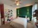 Bedroom with green accent wall, queen bed and eclectic décor at 306 Briar Patch Loop, Davenport, FL 33896
