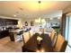 Open concept living: Dining room with elegant lighting connects to a modern kitchen and textured living area at 306 Briar Patch Loop, Davenport, FL 33896