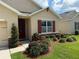 Inviting front entrance with red door, manicured landscaping, and decorative tree at 306 Briar Patch Loop, Davenport, FL 33896