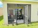 Cozy screened porch features an outdoor dining table, fan, and a serene view of the lush backyard at 306 Briar Patch Loop, Davenport, FL 33896
