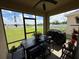 Relaxing screened porch with views of a serene lake, featuring a dining table and a grill for outdoor enjoyment at 306 Briar Patch Loop, Davenport, FL 33896