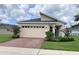 Charming single-story home featuring a brick driveway, two-car garage, and well-manicured landscaping at 3184 Songbird Cir, Harmony, FL 34773