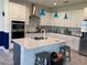 Modern kitchen featuring white cabinets, stainless steel appliances, a kitchen island, and stylish pendant lighting at 3184 Songbird Cir, Harmony, FL 34773