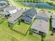 Aerial view showcases a home with a well-maintained lawn, complemented by a tranquil pond and lush landscaping at 3204 Oxbow Ct, St Cloud, FL 34773