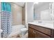 Bathroom with tub-shower combo, tile surround, vanity with sink, and wood-look flooring at 3204 Oxbow Ct, St Cloud, FL 34773