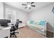 Bedroom featuring a ceiling fan, a workstation, and a daybed with teal-themed pillows and comforter at 3204 Oxbow Ct, St Cloud, FL 34773