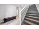 View of the staircase and hallway with tile flooring, bench storage, and neutral paint at 3204 Oxbow Ct, St Cloud, FL 34773