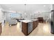 Modern kitchen island with built-in dishwasher, seating, and a view of the living and dining areas at 3204 Oxbow Ct, St Cloud, FL 34773