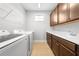 Bright laundry room with modern appliances, plenty of counter space, and wooden cabinets at 3204 Oxbow Ct, St Cloud, FL 34773