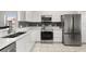 The kitchen features stainless steel appliances, white cabinetry, and a decorative backsplash at 3217 Whooping Crane Run, Kissimmee, FL 34741