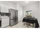 The kitchen features stainless steel appliances, white cabinetry, decorative backsplash and breakfast table at 3217 Whooping Crane Run, Kissimmee, FL 34741