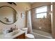 Bathroom features a shower-tub combo, round mirror, and neutral wall colors at 406 Cinnamon Dr, Kissimmee, FL 34759
