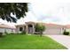 Charming single-story home featuring a well-manicured lawn, a red-tiled roof, and an attached two-car garage at 406 Cinnamon Dr, Kissimmee, FL 34759