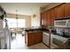 Bright kitchen featuring wood cabinetry, white appliances, granite counters, and a breakfast nook at 406 Cinnamon Dr, Kissimmee, FL 34759