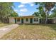Charming single-story home with a well-maintained lawn and mature trees on a sunny day at 441 Kentia Rd, Casselberry, FL 32707