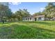 Large grassy backyard with a glimpse of a house with a sunroom at 4805 Jay Dr, St Cloud, FL 34772