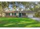 Charming single-story home with a brick facade, blue shutters, manicured lawn, and mature trees at 4805 Jay Dr, St Cloud, FL 34772