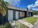 The exterior of the building featuring a sidewalk leading to two entry doors, security bars, and an ample parking area at 4950 Silver Star Rd, Orlando, FL 32808