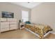 Cozy bedroom featuring hardwood floors, neutral paint, and a small window for natural light at 608 Wechsler Cir, Orlando, FL 32824