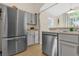 Stainless steel appliances, including a refrigerator and dishwasher, complement the modern kitchen at 608 Wechsler Cir, Orlando, FL 32824