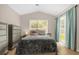 Bright main bedroom featuring a tall ceiling, large window, and sliding door access to the backyard at 608 Wechsler Cir, Orlando, FL 32824