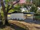 Charming home with a white exterior, black roof, and a covered carport at sunset at 7043 Carlene Dr, Orlando, FL 32835