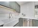Close-up of a new farmhouse sink with modern faucet and stainless steel dishwasher at 7043 Carlene Dr, Orlando, FL 32835