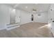 A brightly lit living room with a doorway to a bathroom, light wood floors, and neutral walls at 7043 Carlene Dr, Orlando, FL 32835