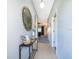 Bright hallway featuring a console table with a round mirror, and tile flooring blending seamlessly into a carpeted living space at 746 Terra Lago St, Davenport, FL 33897