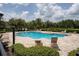 Community pool with lounge chairs surrounded by lush landscaping and a secure fence at 7621 Sutherton Ln, Windermere, FL 34786