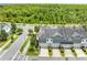 Aerial view of beautiful gray townhomes with attached garages adjacent to a lush green space at 9121 Laureate Blvd, Orlando, FL 32827