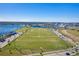 Extensive recreational area featuring a large grassy field, sports facilities, and a lake in a vibrant community at 9121 Laureate Blvd, Orlando, FL 32827