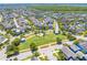 An aerial view showcases a beautifully planned community with a central park, homes, and green spaces, and mature trees at 9121 Laureate Blvd, Orlando, FL 32827