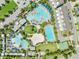 An aerial shot highlights a community's multiple pools, sports courts, and recreational zones surrounded by lush landscaping at 9121 Laureate Blvd, Orlando, FL 32827