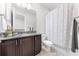 Bathroom featuring dark cabinets, granite countertop, and shower and tub with white curtain at 9121 Laureate Blvd, Orlando, FL 32827
