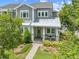 Charming two-story home with landscaped yard, covered porch, and inviting green door at 9121 Laureate Blvd, Orlando, FL 32827