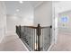 Upstairs hallway with neutral walls, carpet, and wood and wrought iron staircase at 9121 Laureate Blvd, Orlando, FL 32827