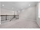 Spacious loft area with neutral walls, carpet flooring, and staircase with decorative metal spindles at 9121 Laureate Blvd, Orlando, FL 32827