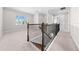 Upstairs loft area featuring neutral walls, carpet, staircase, and large windows providing natural light at 9121 Laureate Blvd, Orlando, FL 32827