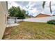 Backyard view with beige house, enclosed patio, and white privacy fence at 10934 Rushwood Way, Clermont, FL 34714