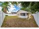 Spacious backyard with a screened-in porch and well-maintained white fence at 10934 Rushwood Way, Clermont, FL 34714