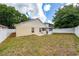 Backyard view with beige house, enclosed patio, and white fence at 10934 Rushwood Way, Clermont, FL 34714